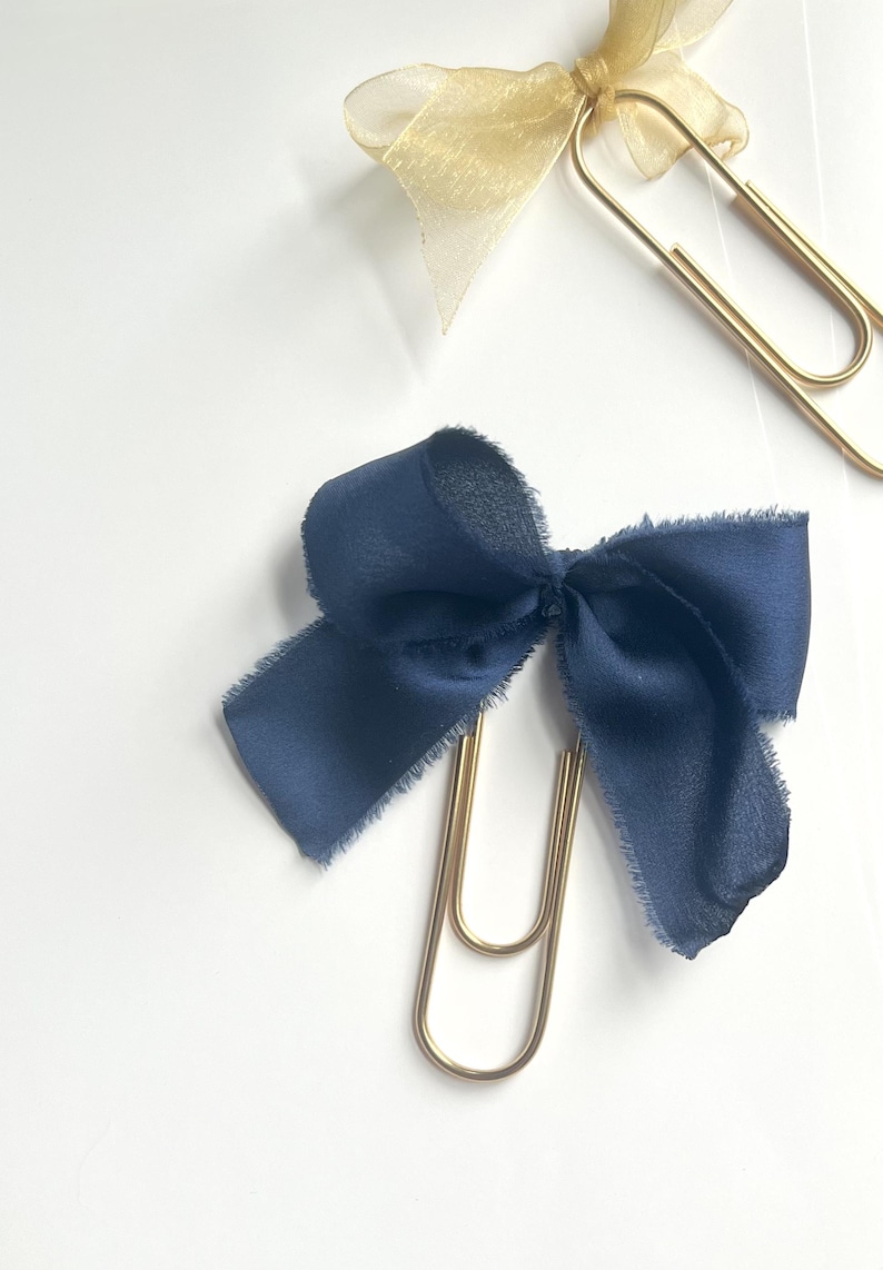 Oversized gold paper clips with a blue bow