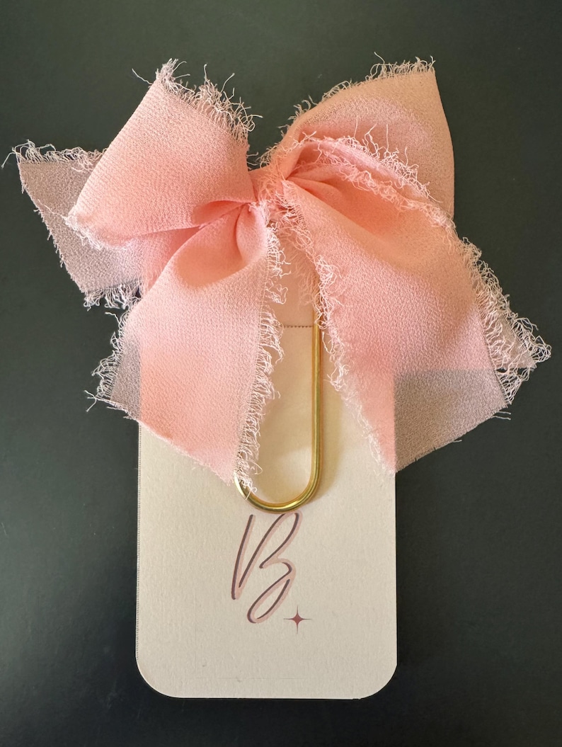 Oversized gold paper clips with a pink bow